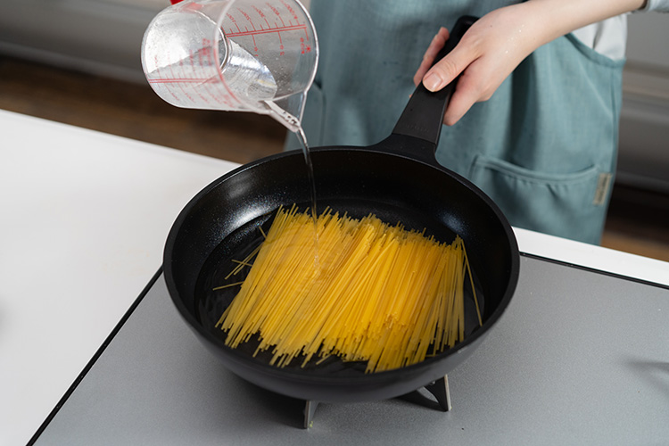 スパゲティは長さを半分に折って入れる