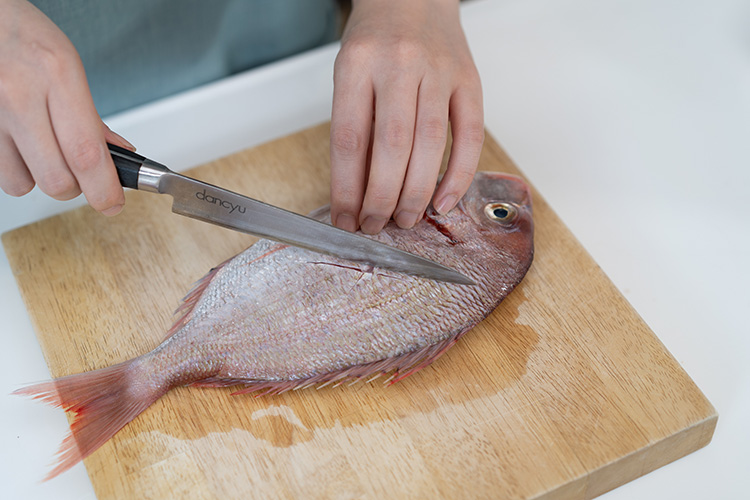 鯛は皮目に浅く十字に切り込みを入れる