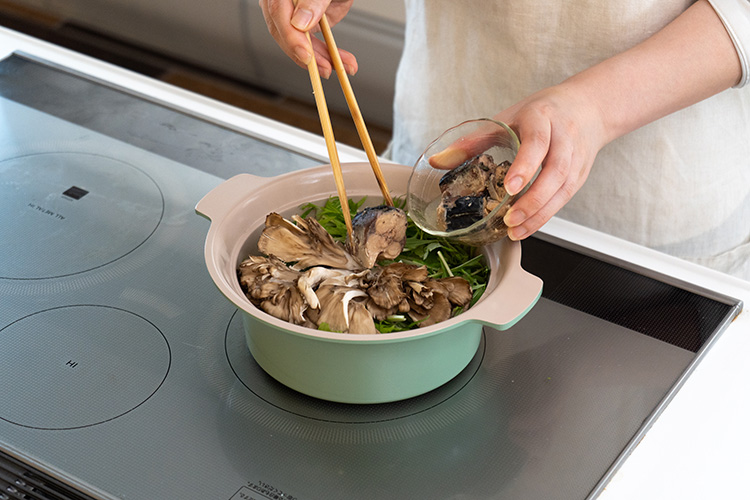 鍋にかぶ、しょうが、梅干しを入れる。さらに水菜、まいたけの順に加え、最後に鯖缶(水煮)を汁ごと加える。